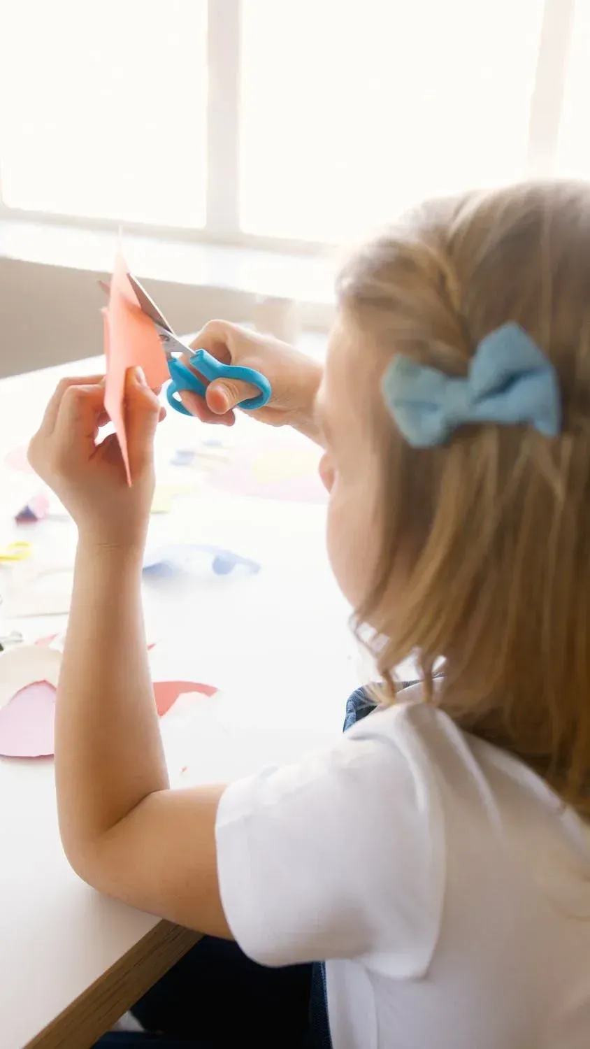 petite fille coupe du papier