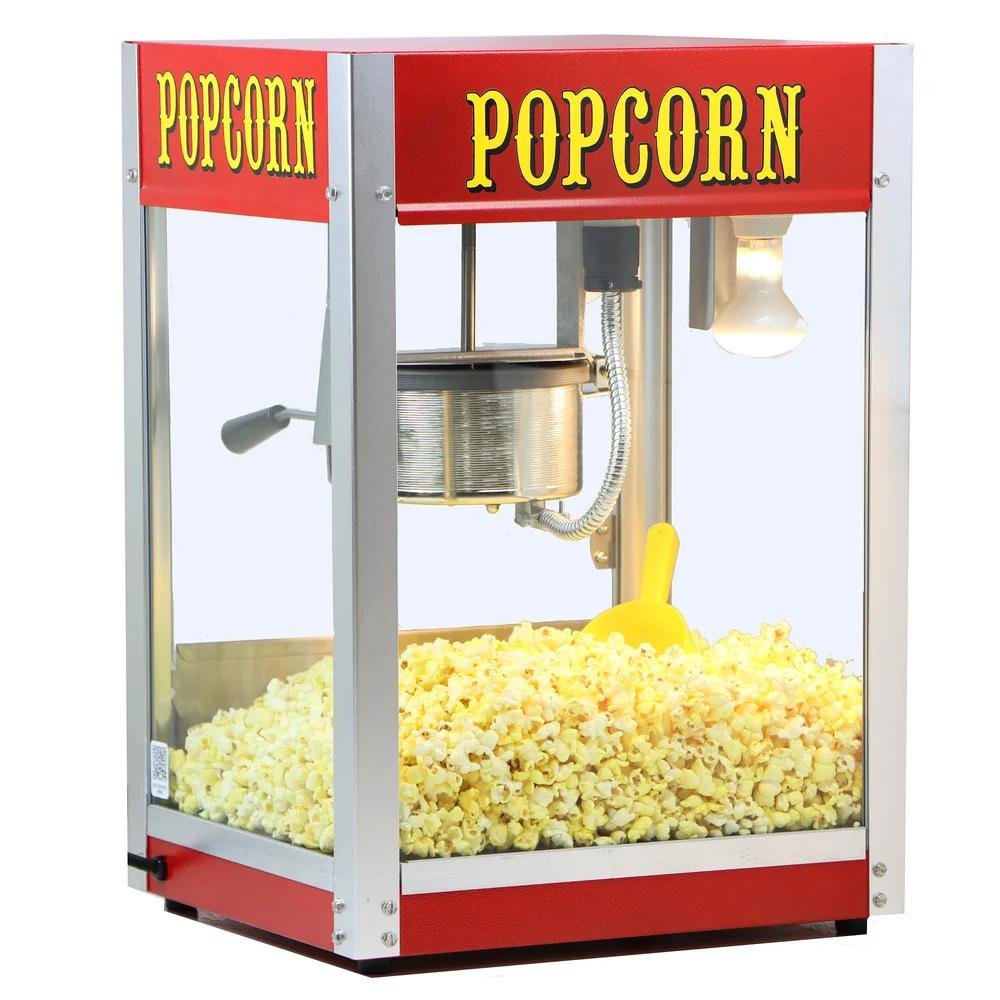 A red and silver popcorn machine filled with popcorn