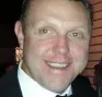 Man with short hair smiles at the camera, wearing a dark suit and bow tie.