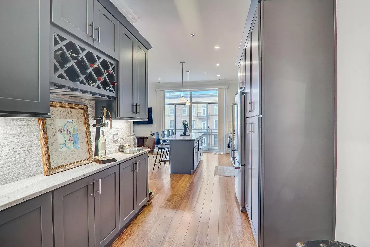 a kitchen with gray cabinets and stainless steel appliances and a wine rack .