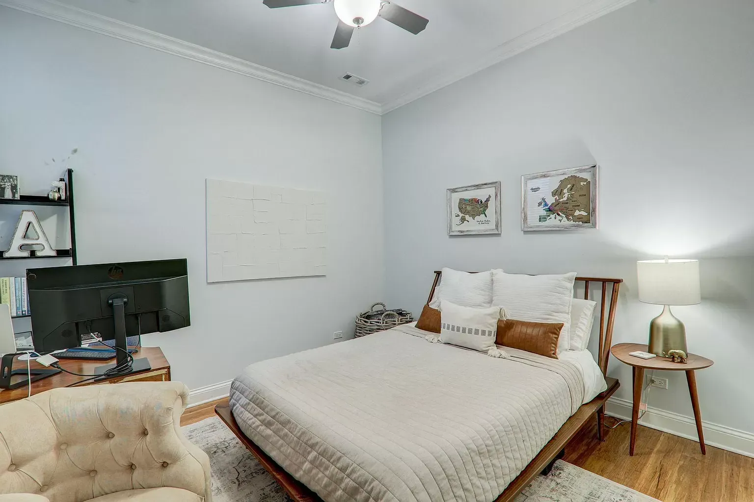 a bedroom with a bed , chair , desk and ceiling fan .