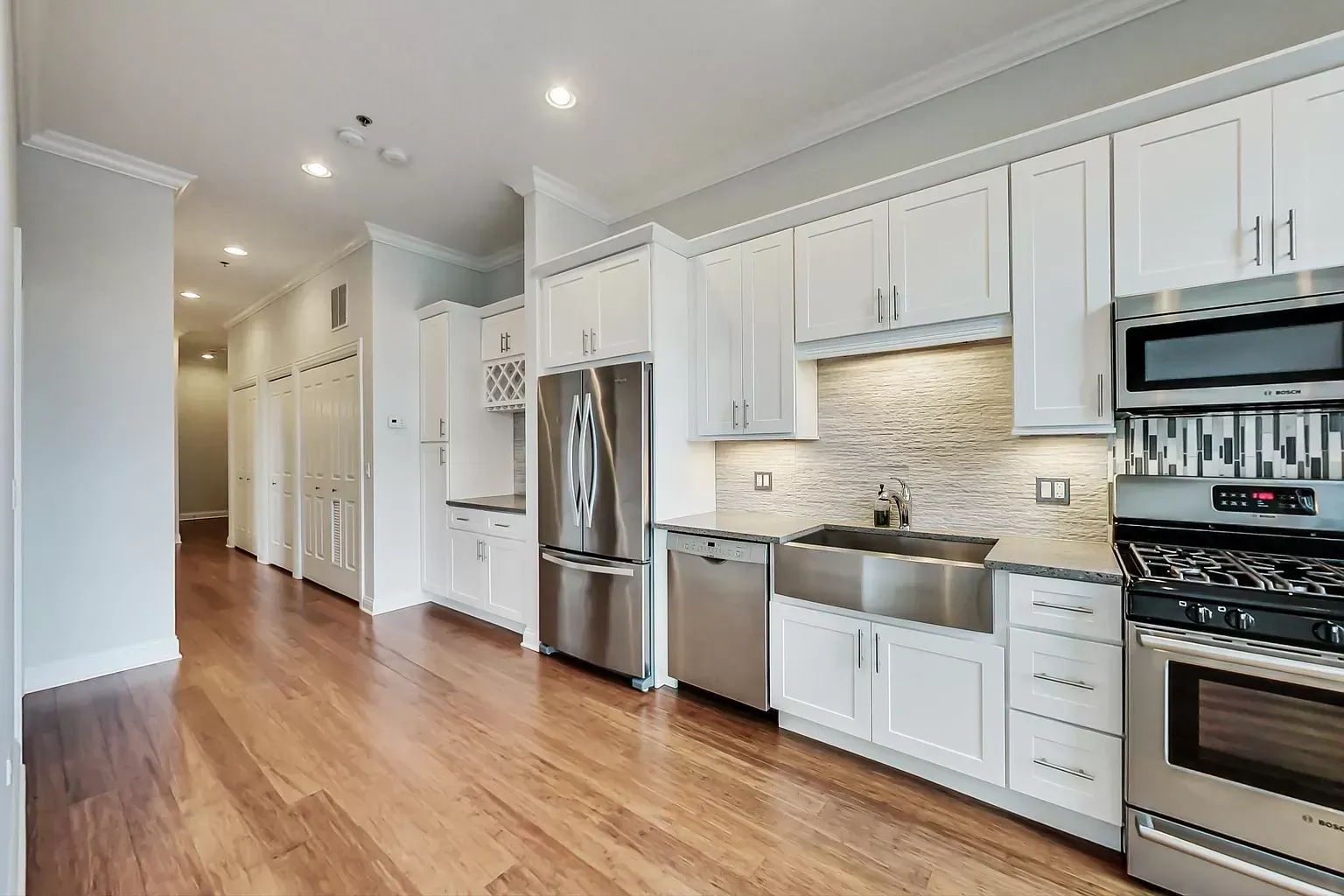 a kitchen with white cabinets and stainless steel appliances .