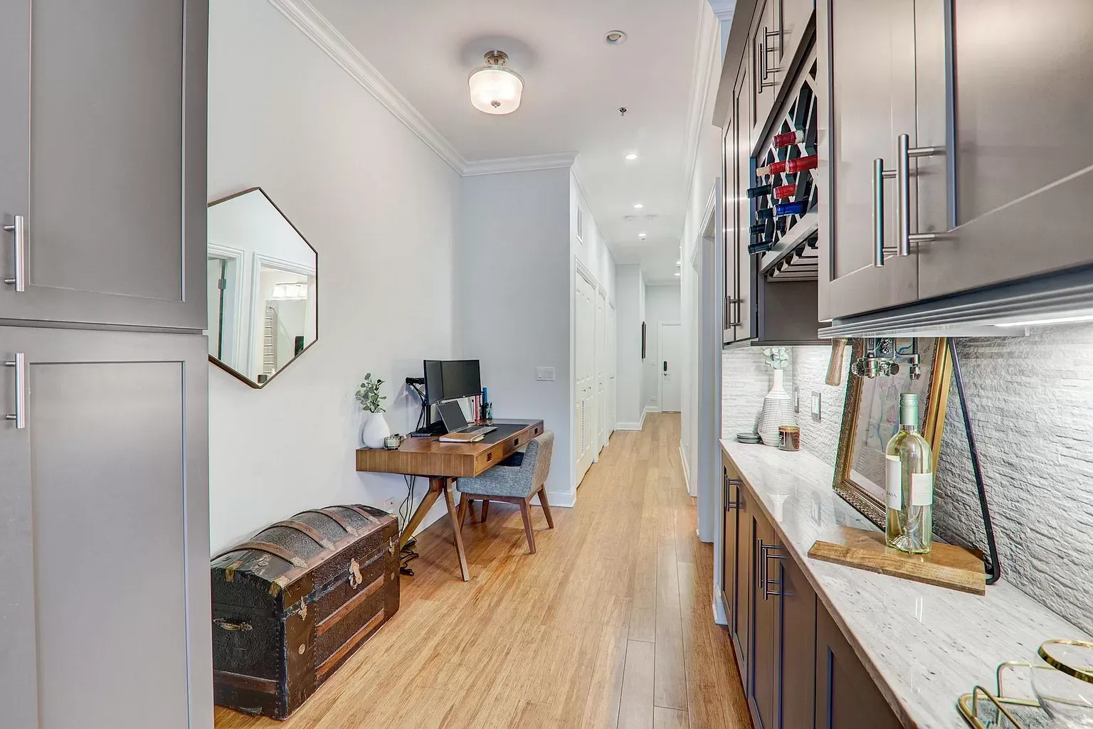 a hallway with a desk and a trunk in it .