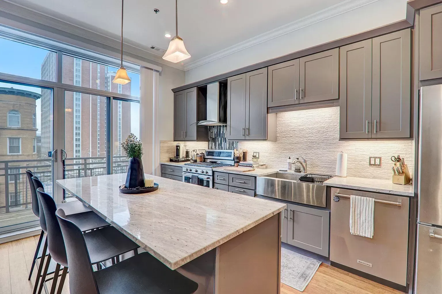 a kitchen with a large island and stainless steel appliances .