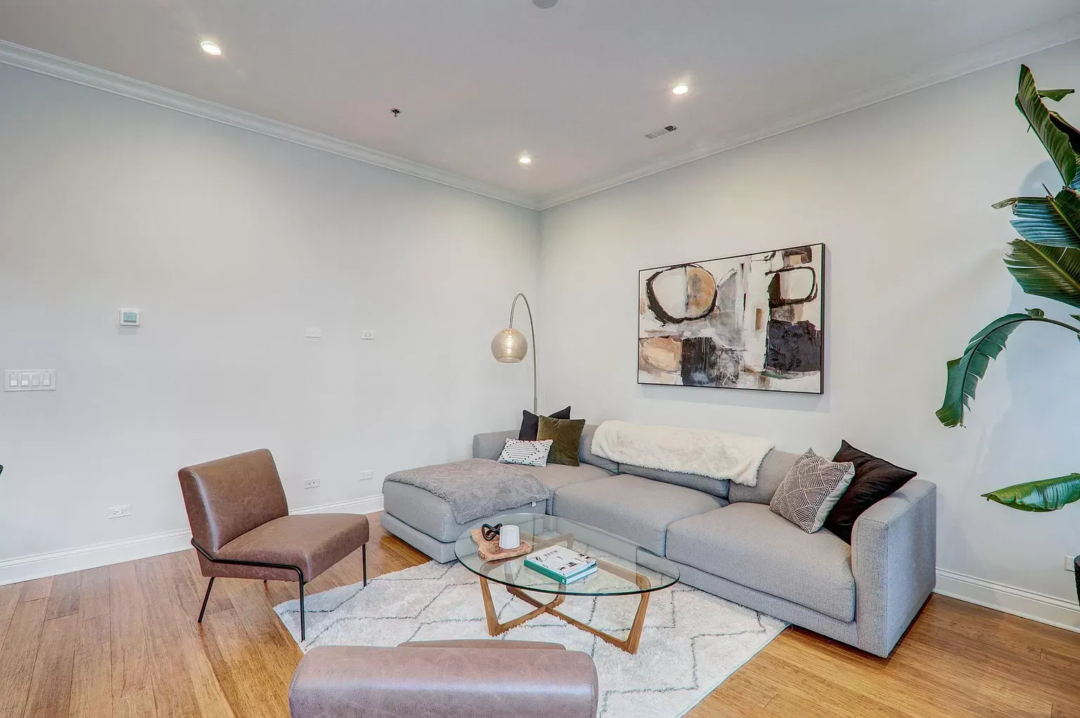 a living room with a couch , chair , coffee table and painting on the wall .