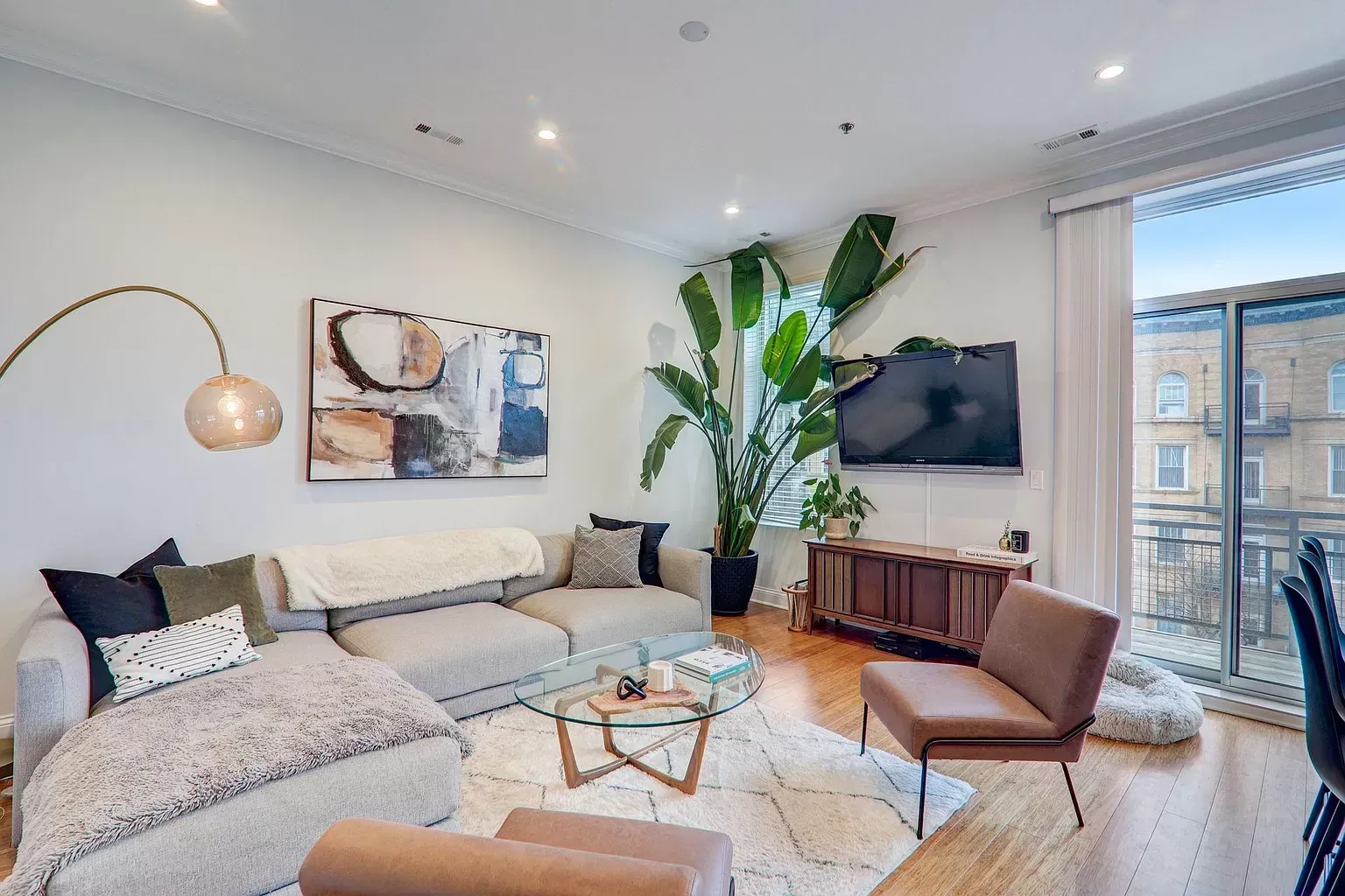 a living room with a couch , chair , coffee table and television .