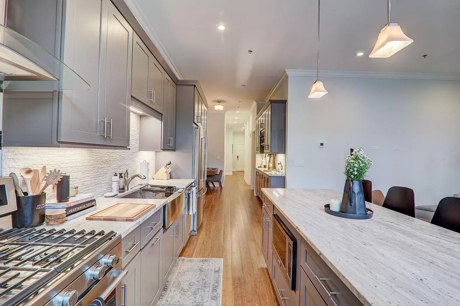 a kitchen with stainless steel appliances , granite counter tops , and gray cabinets .