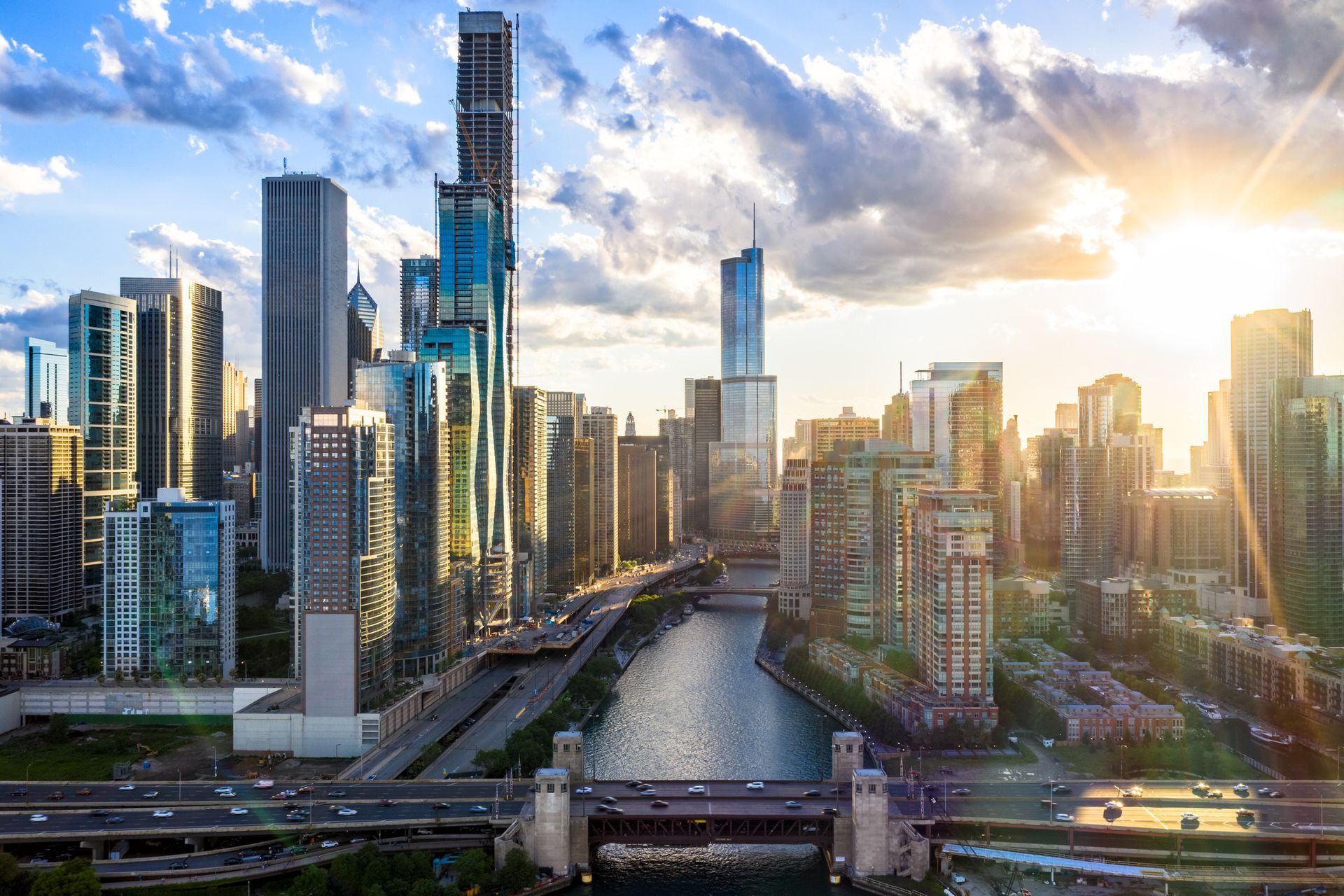 an aerial view of a city skyline at sunset with a river in the foreground .