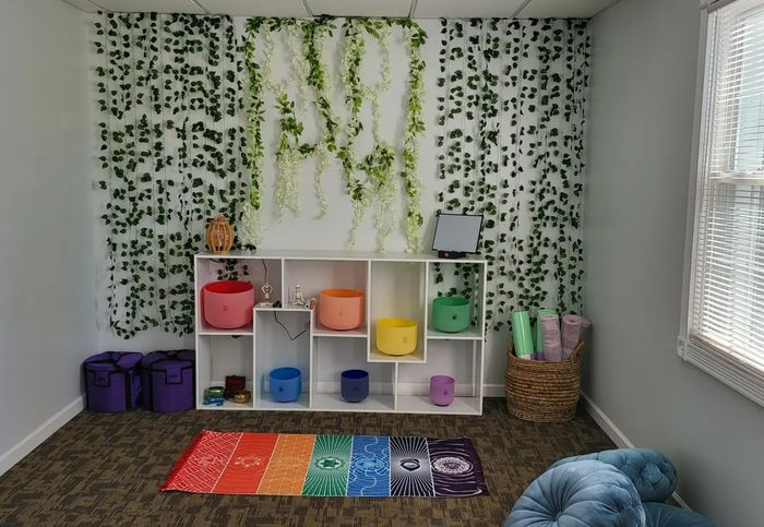 A room with a rainbow rug and a shelf with bowls on it.