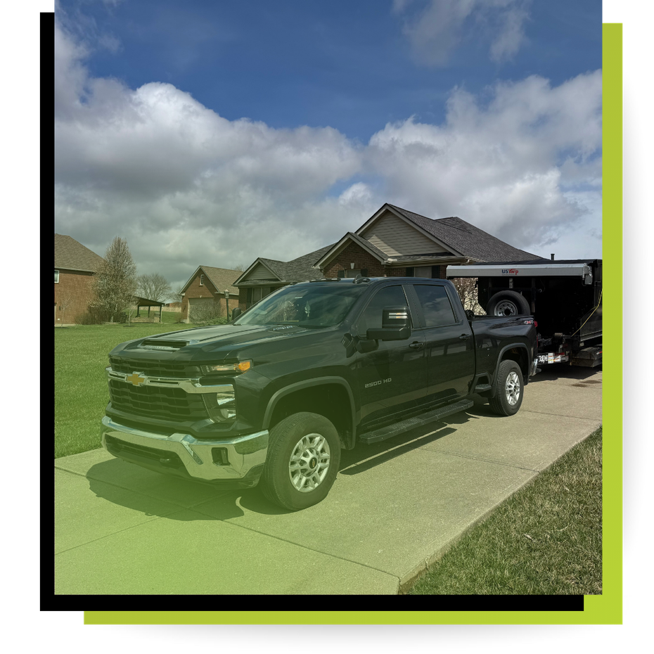 Tru-clean dumpster truck in fornt of a house