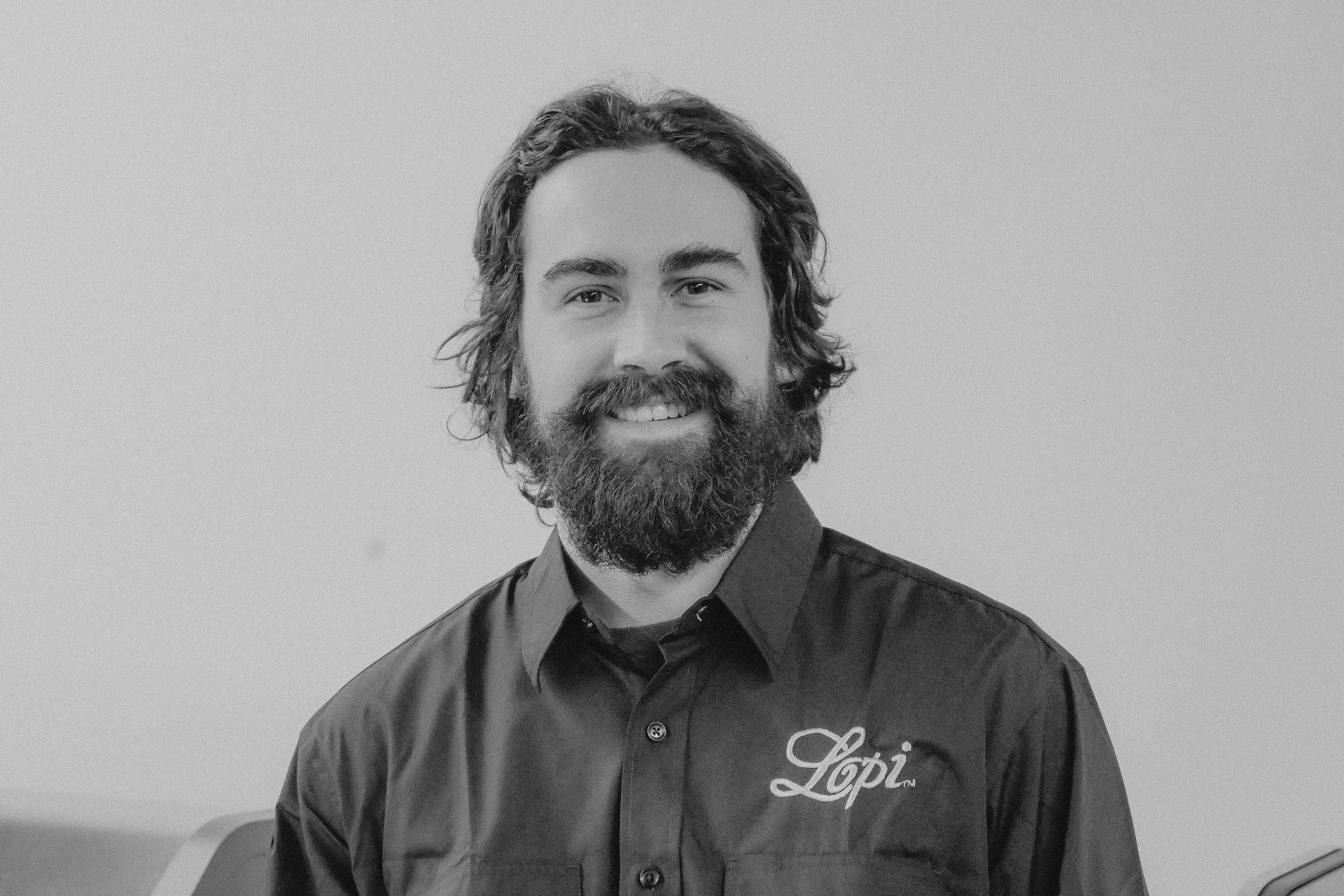 Man with a beard, wearing a dark shirt with