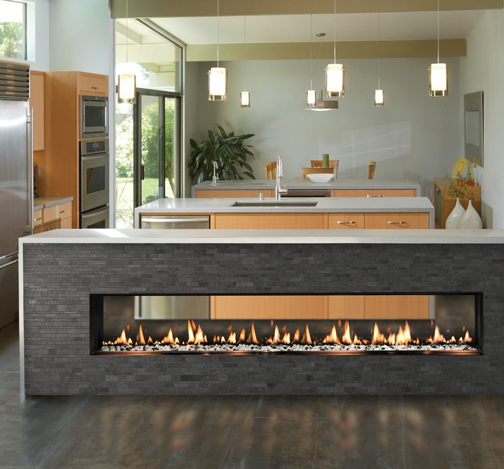 Modern kitchen with island fireplace; neutral tones, wood cabinets, stainless steel appliances, and hanging lights.