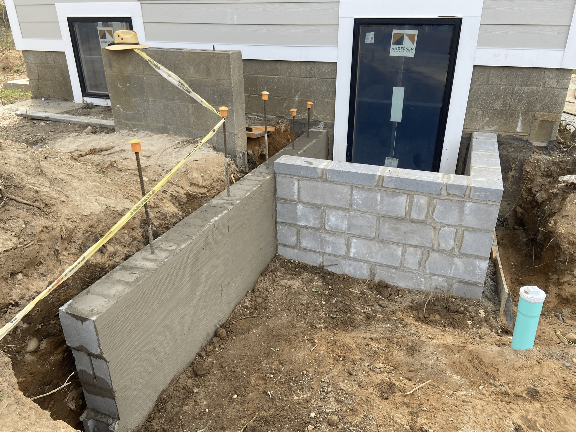 A brick wall is being built in front of a house.