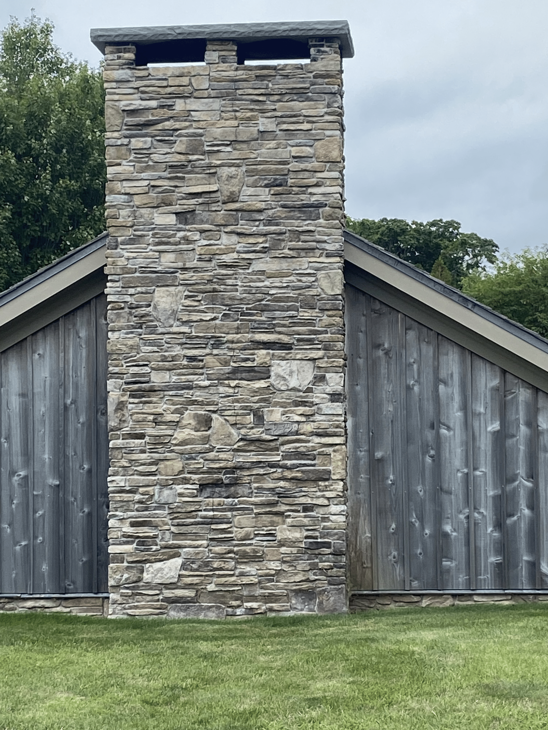 A large stone chimney on the side of a building