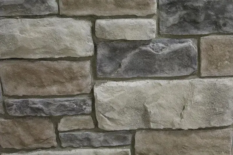 Gray and beige stacked stone wall with rough rectangular blocks