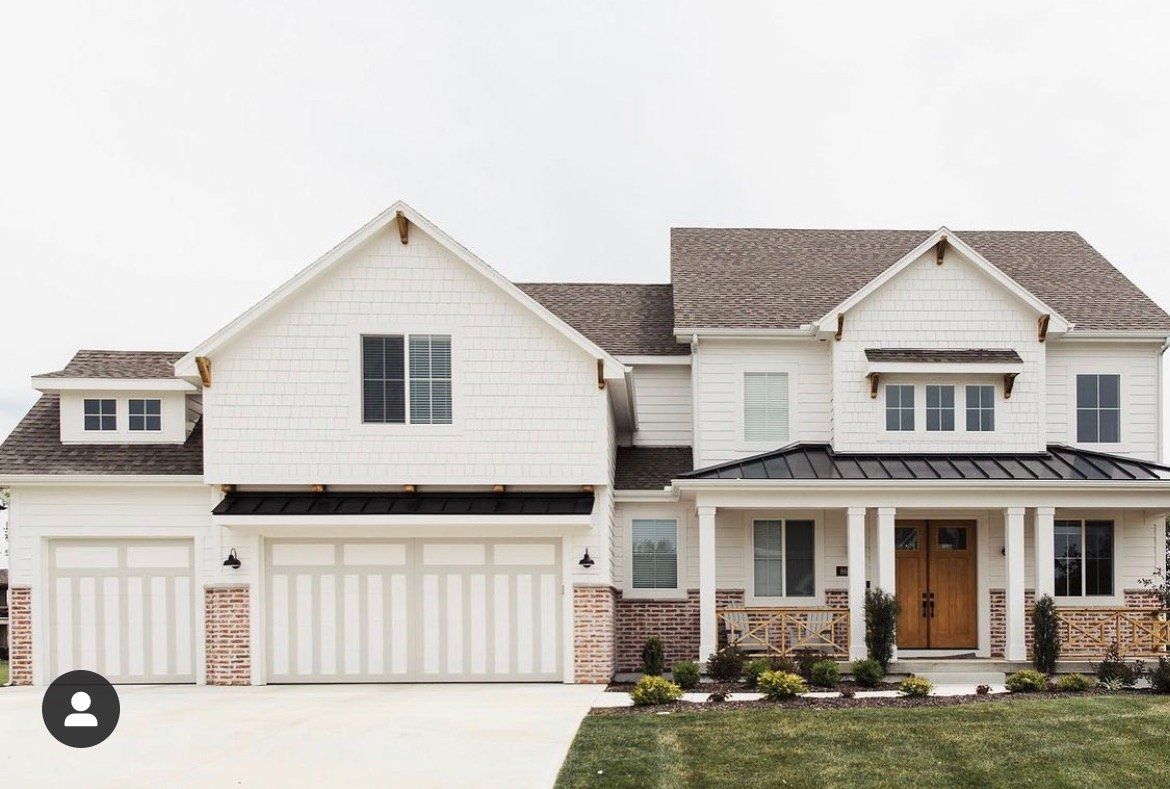 Large white suburban house with attached garage, front porch, and well-kept lawn