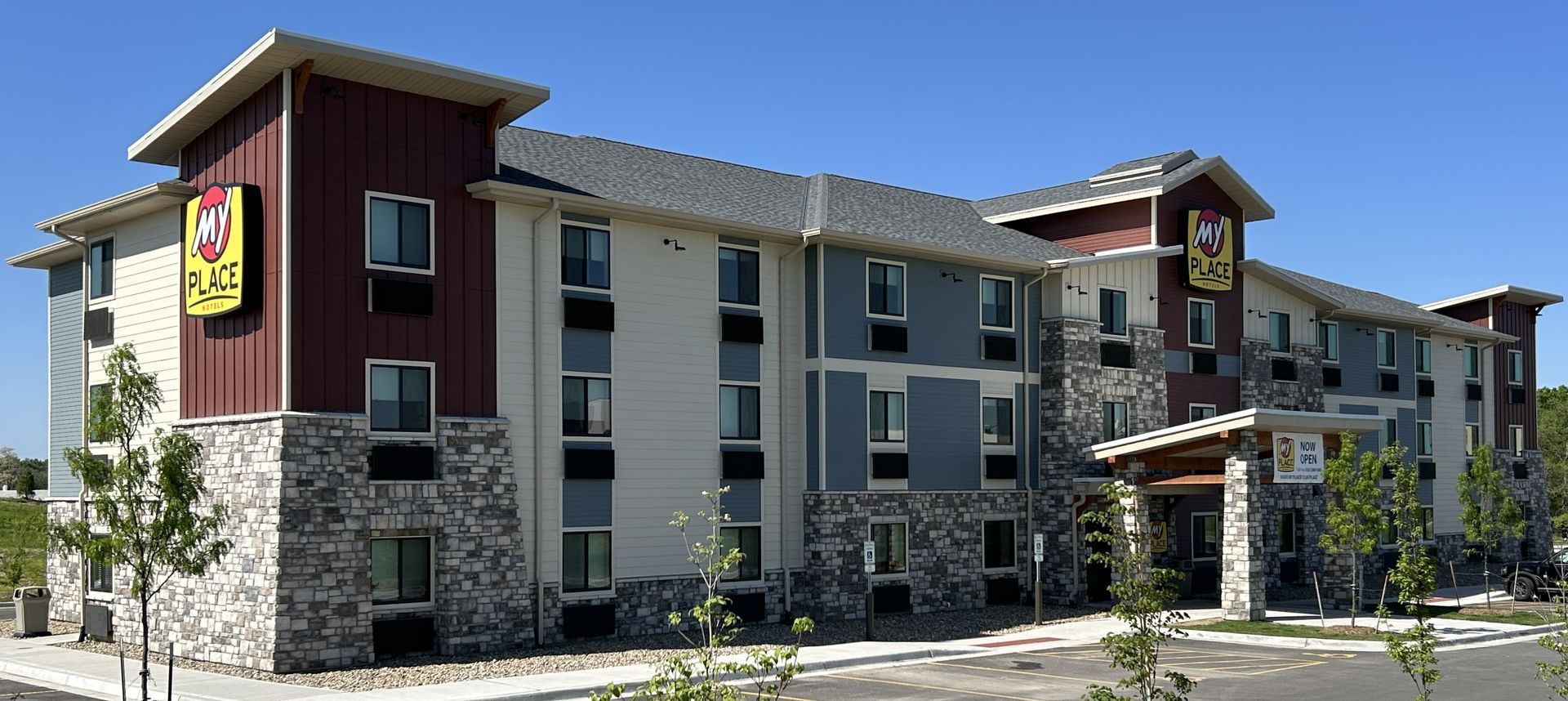 Exterior of a modern Best Western hotel with stone and beige siding under a clear sky