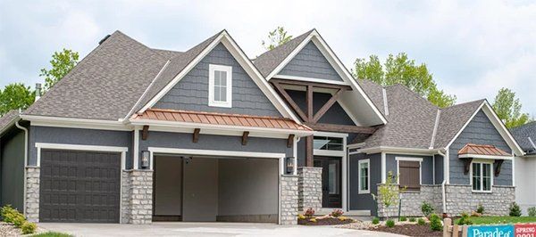 Modern gray house with two garages, gabled rooflines, and a front porch
