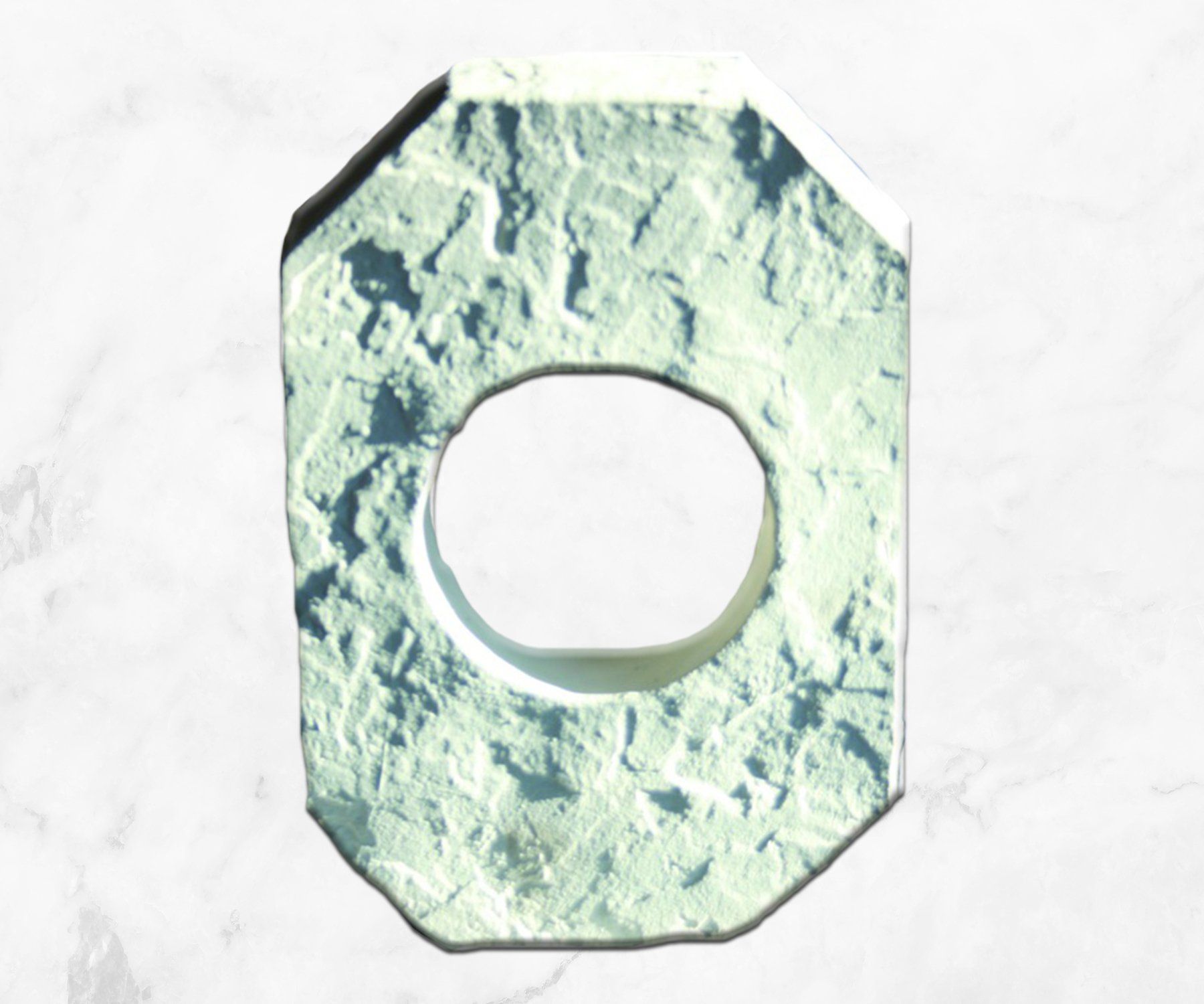 Pale green textured washer with a round center hole on a white background