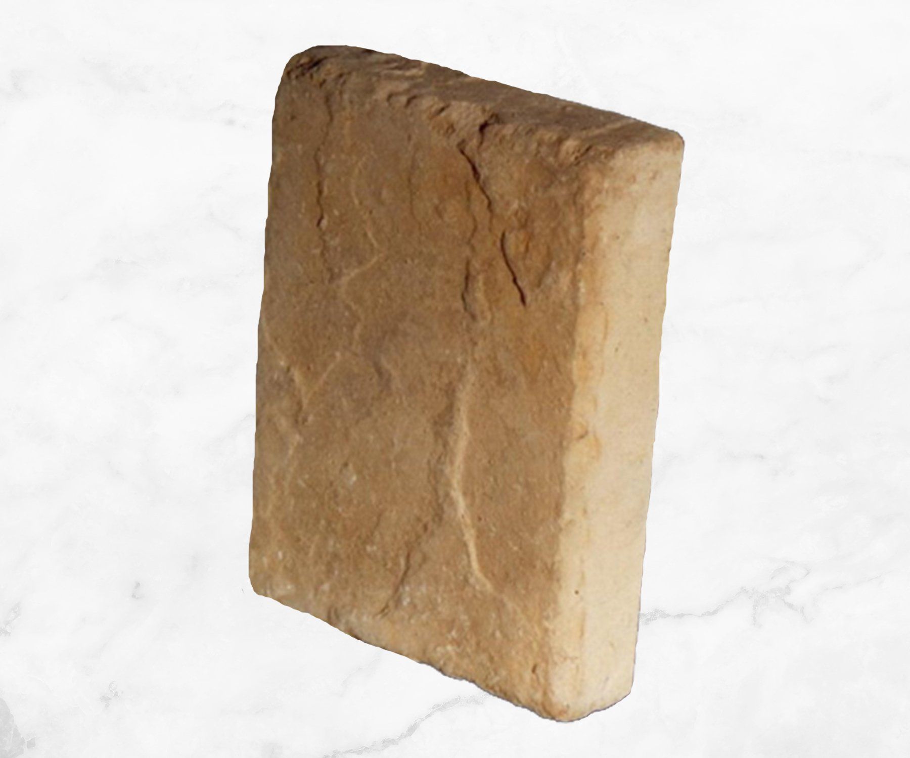 A small tan rectangular stone block with a rough, uneven surface on a white background
