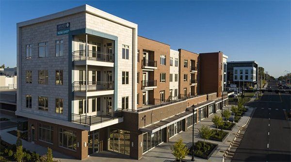 Modern apartment building complex with balconies along a sunny street