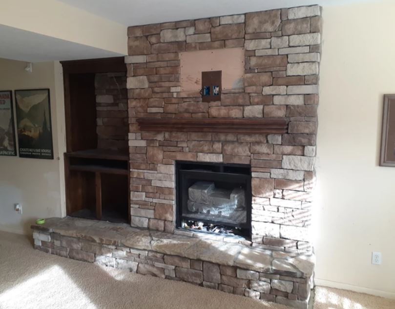 Stone fireplace with raised hearth and built-in shelves in a living room