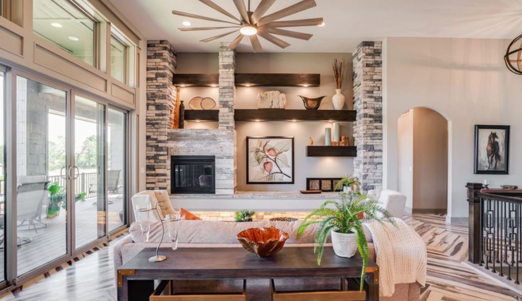 Bright open-plan living room with built-in shelves, fireplace, dining table, and large sliding glass doors