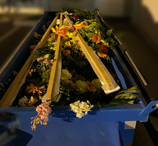 A blue bin filled with flowers and leaves
