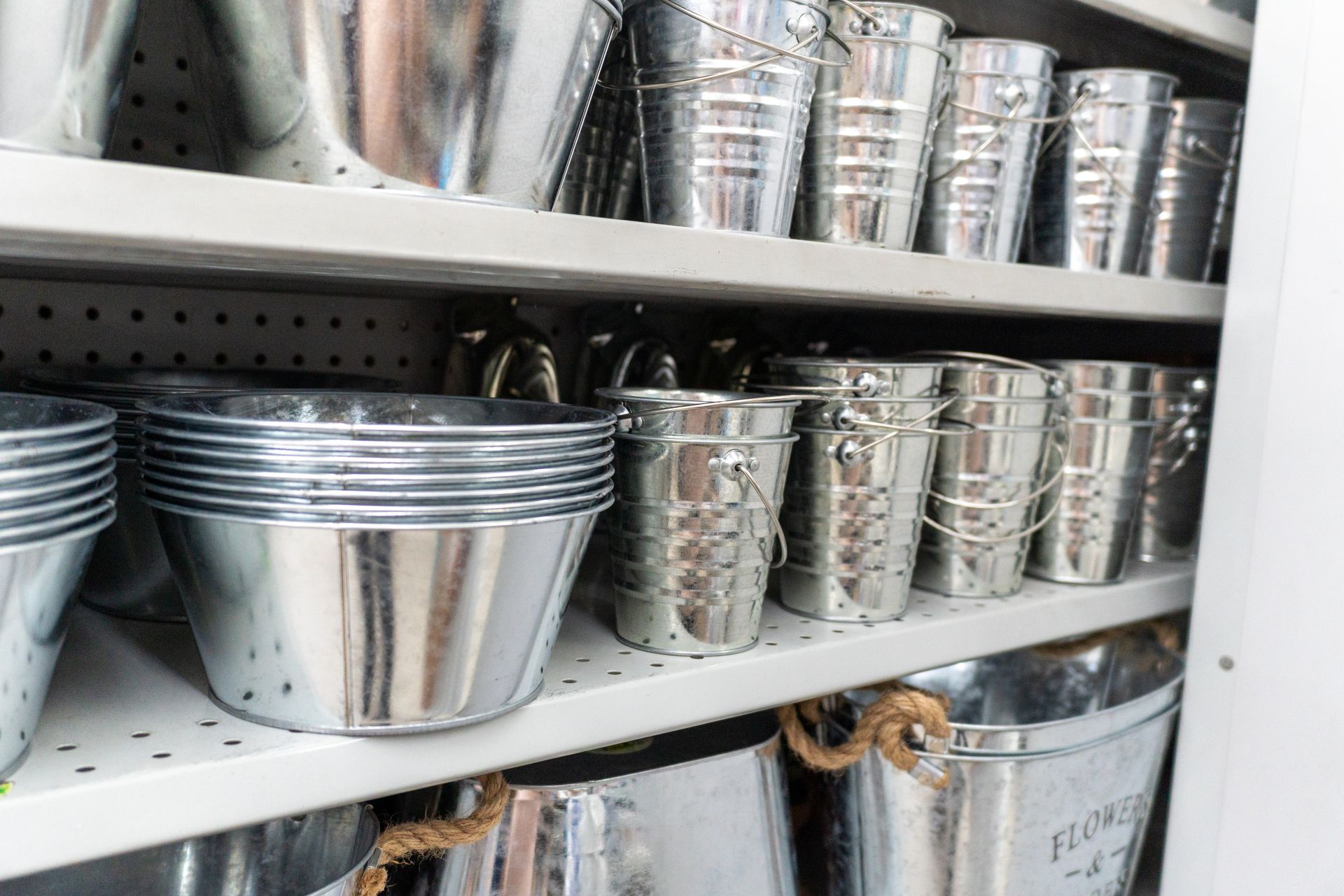 Shelves filled with various galvanized metal buckets and containers. Shelves filled with various galvanized metal buckets and containers.