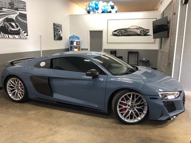A blue audi r8 is parked in a garage.