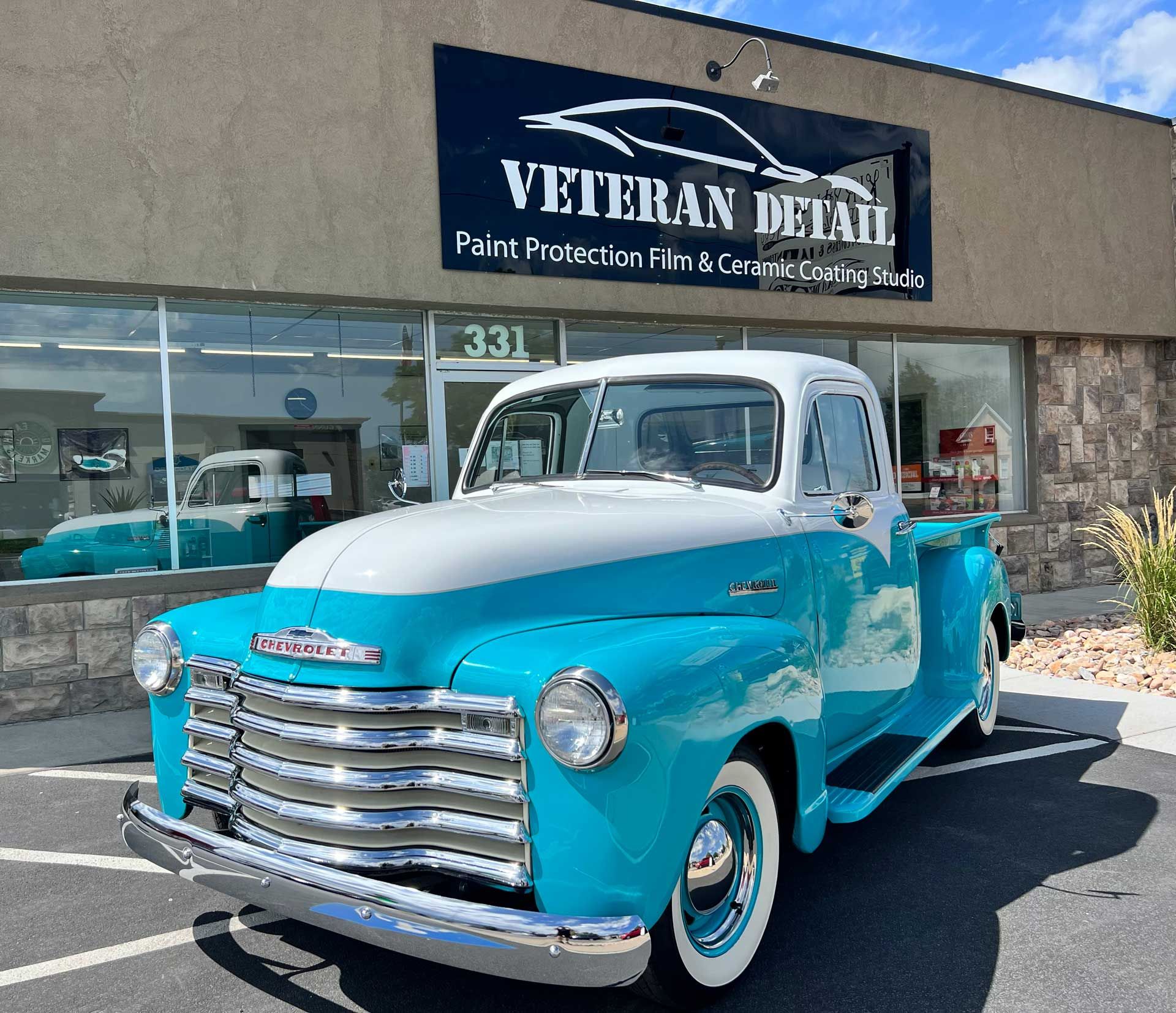 A blue and white truck is parked in front of veteran detail