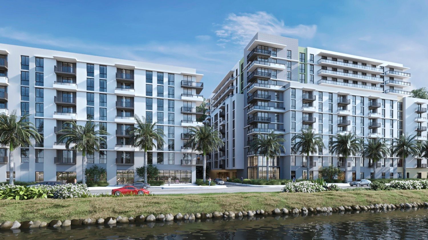 Modern waterfront apartment buildings with balconies and palm trees by the water