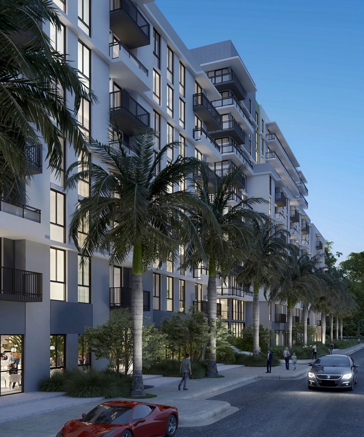 Modern apartment building with palm trees along a street at dusk