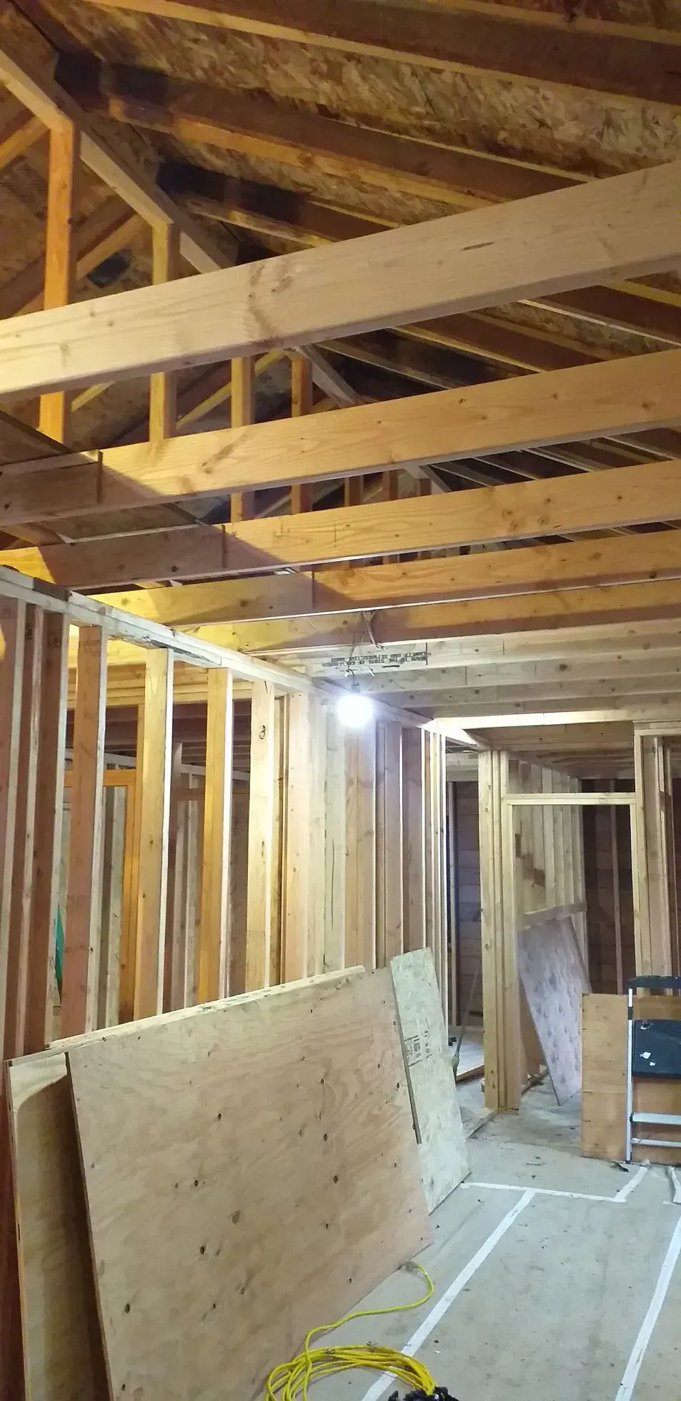 Interior of a building under construction. Wooden framework, exposed beams, and plywood sheets.