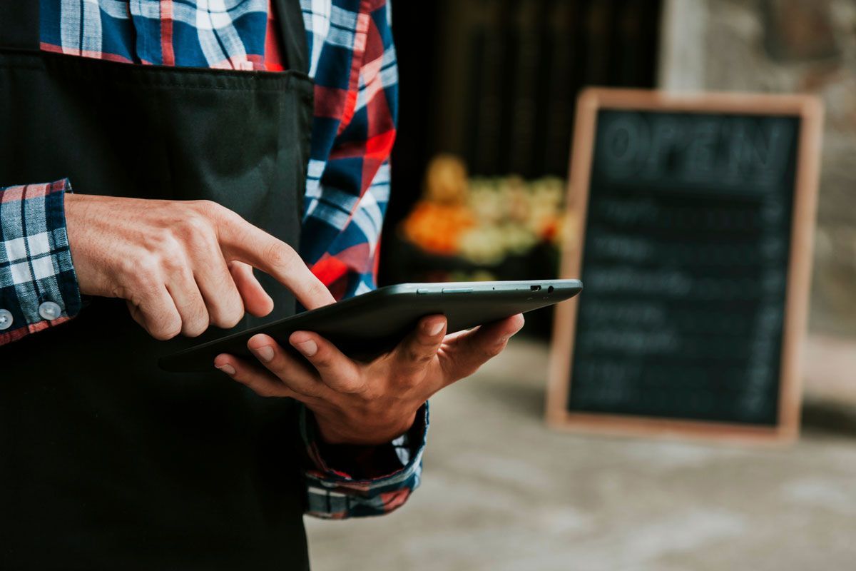 Worker using a tablet to manage workplace operations and employee safety needs