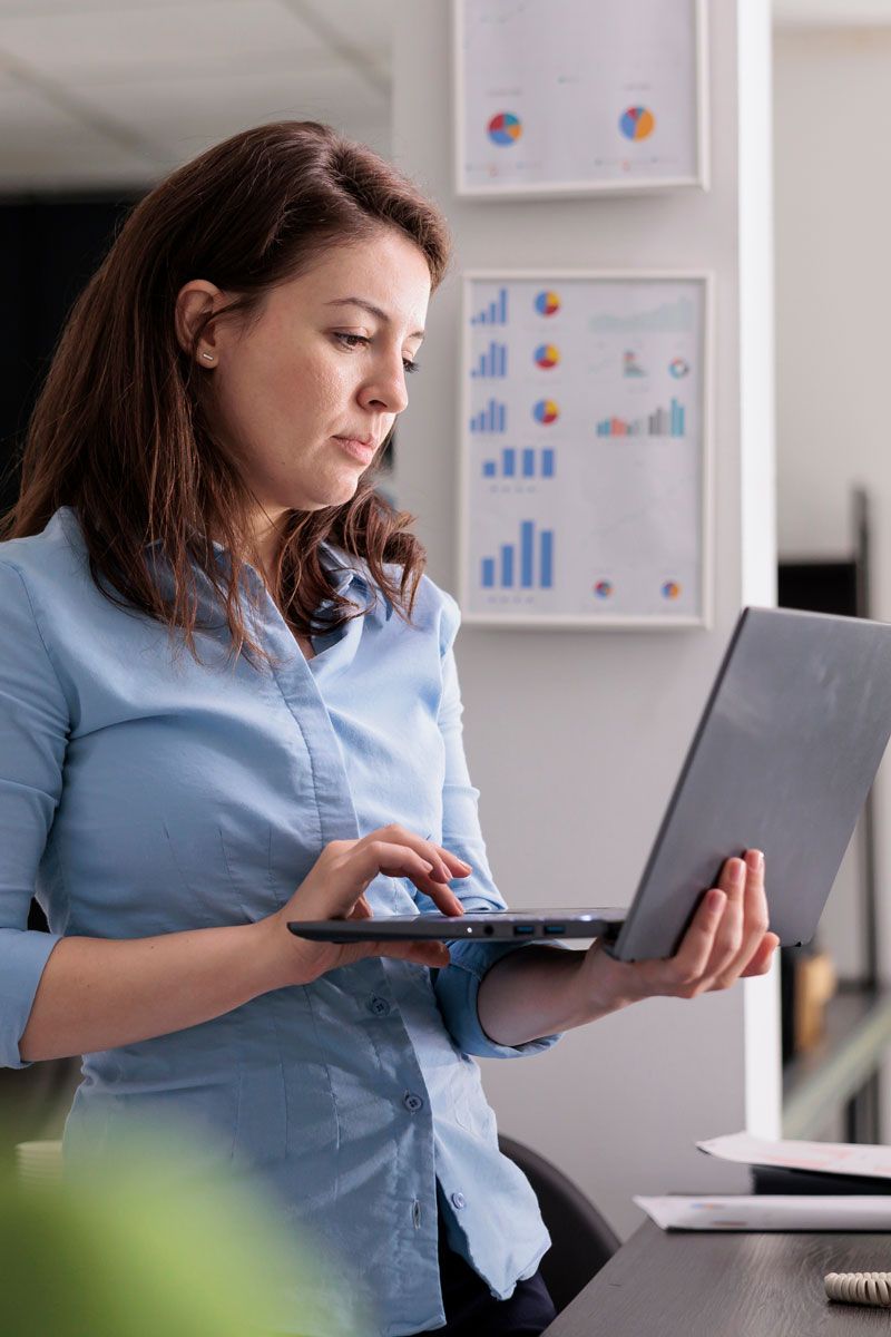 Business owner using a laptop to manage outsourced HR, payroll, and compliance tasks