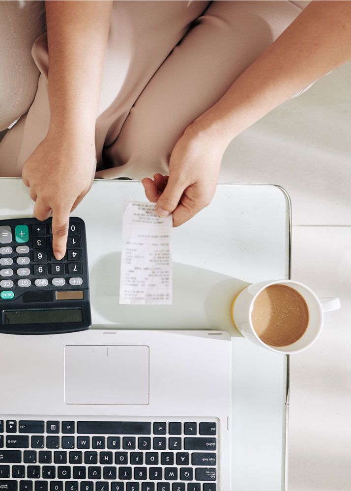Person using a calculator and receipt to review business expenses and bookkeeping records