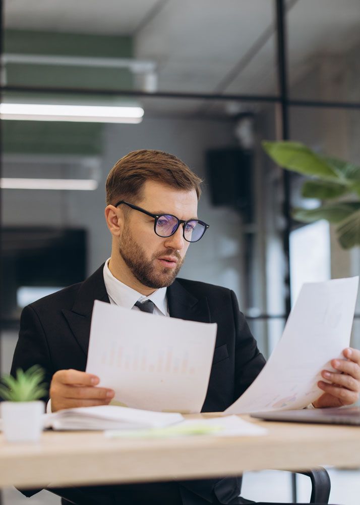 Business professional reviewing financial documents at a desk for payroll processing and management