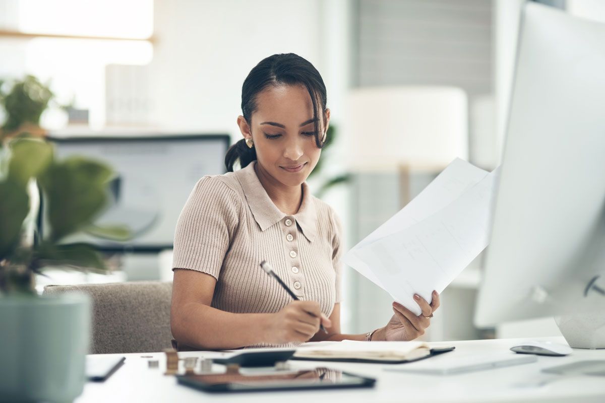 Professional reviewing payroll paperwork at a desk for PEO payroll services