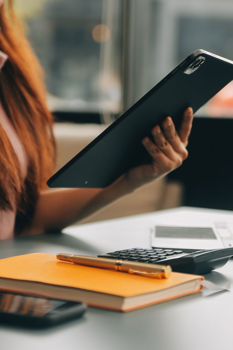 Professional reviewing payroll and HR documents with a calculator for PEO support services