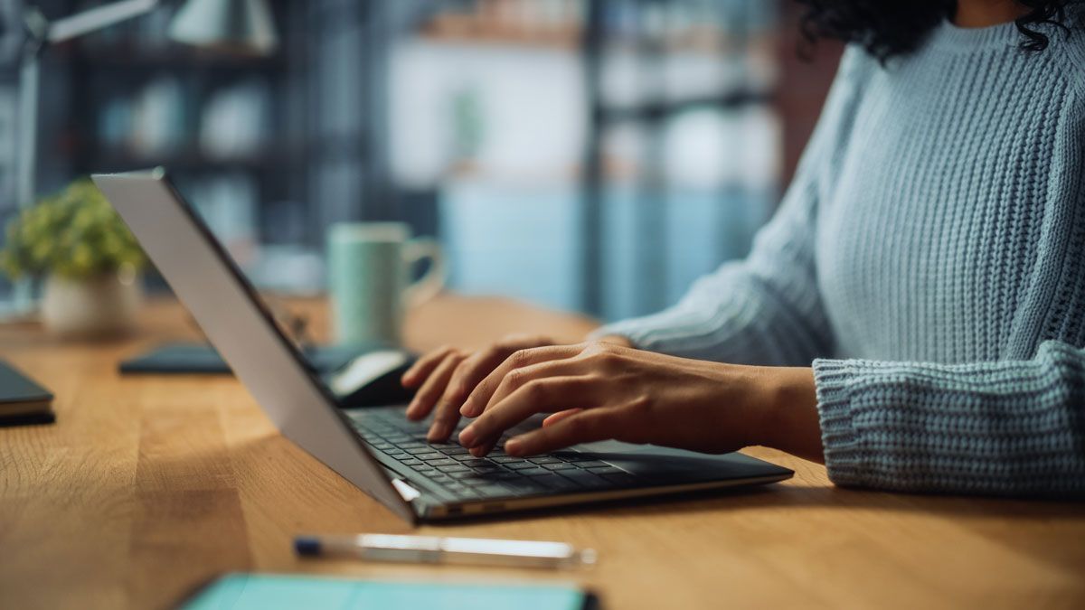 Business professional using a laptop to manage employee benefits information