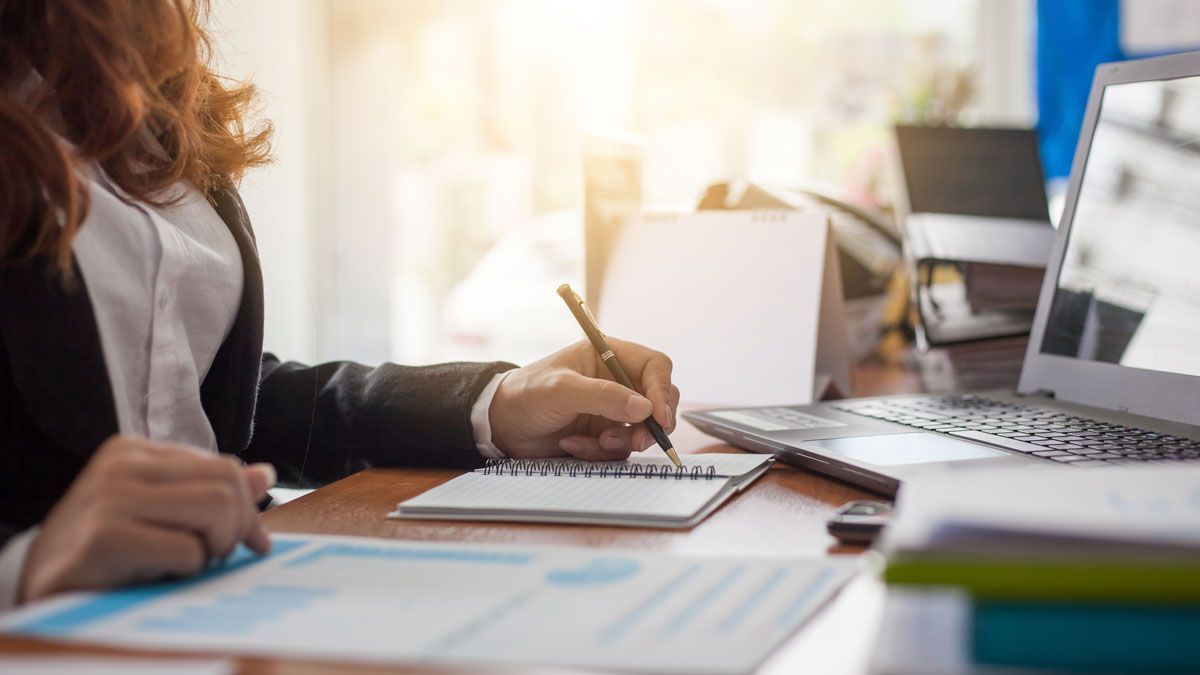 Bookkeeper reviewing financial reports and recording business expenses