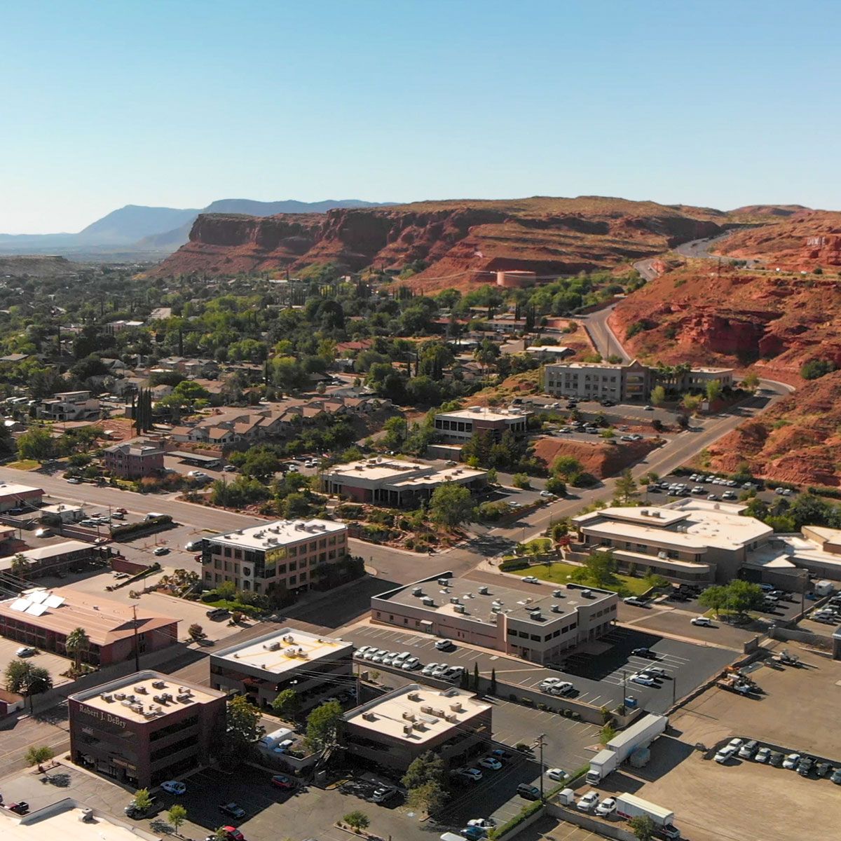 Aerial view of businesses and red sandstone cliffs in St. George, Utah