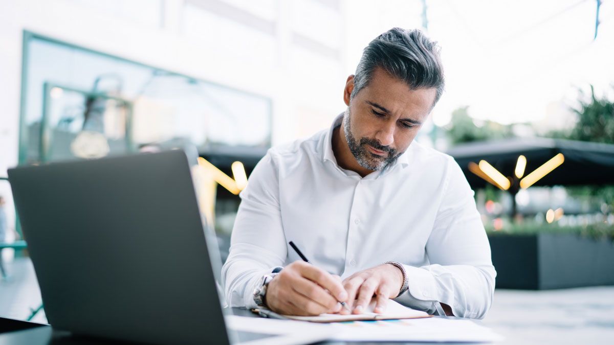 St. George business owner completing paperwork beside a laptop