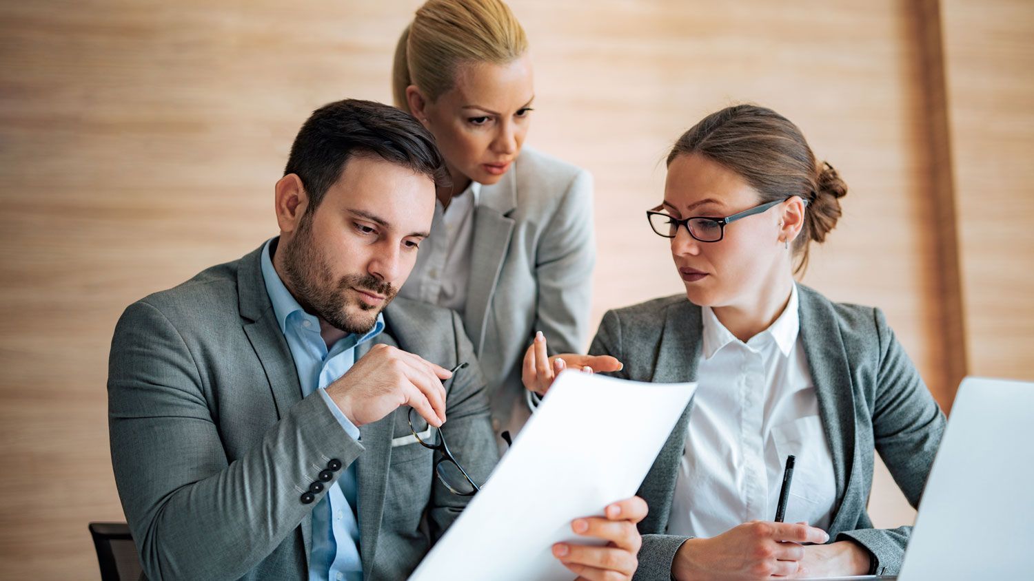 HR professionals reviewing employee benefits documents to improve next year's open enrollment process.