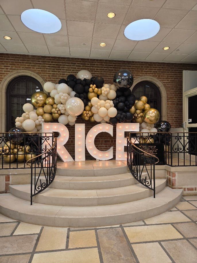 Pastel balloon arch framing glass doors at an evening event venue