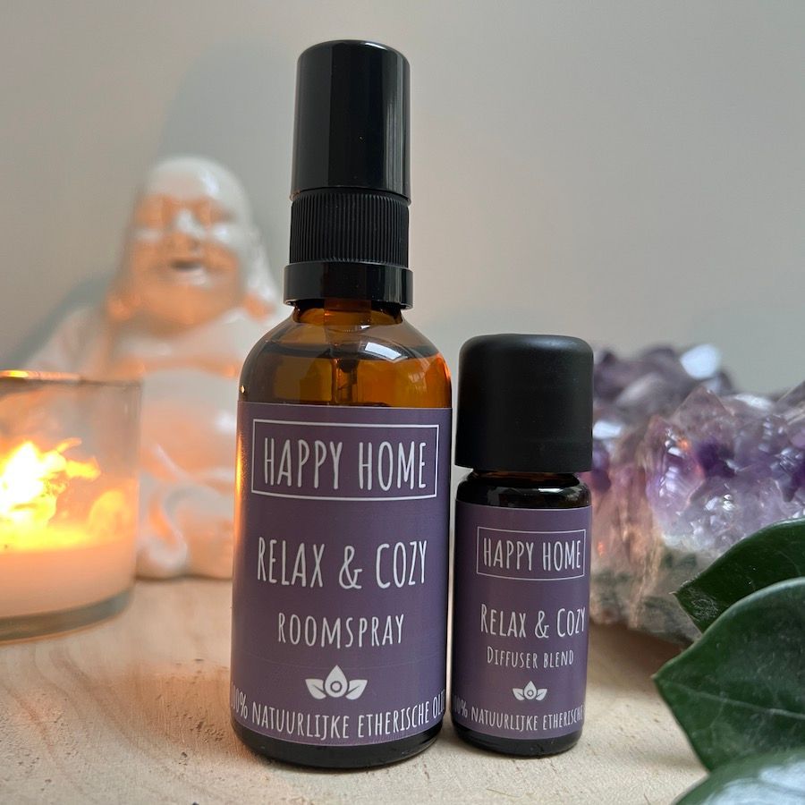 Twee flesjes lavendelspray op een tafel met een brandende kaars en een achtergrond van amethistkristallen.