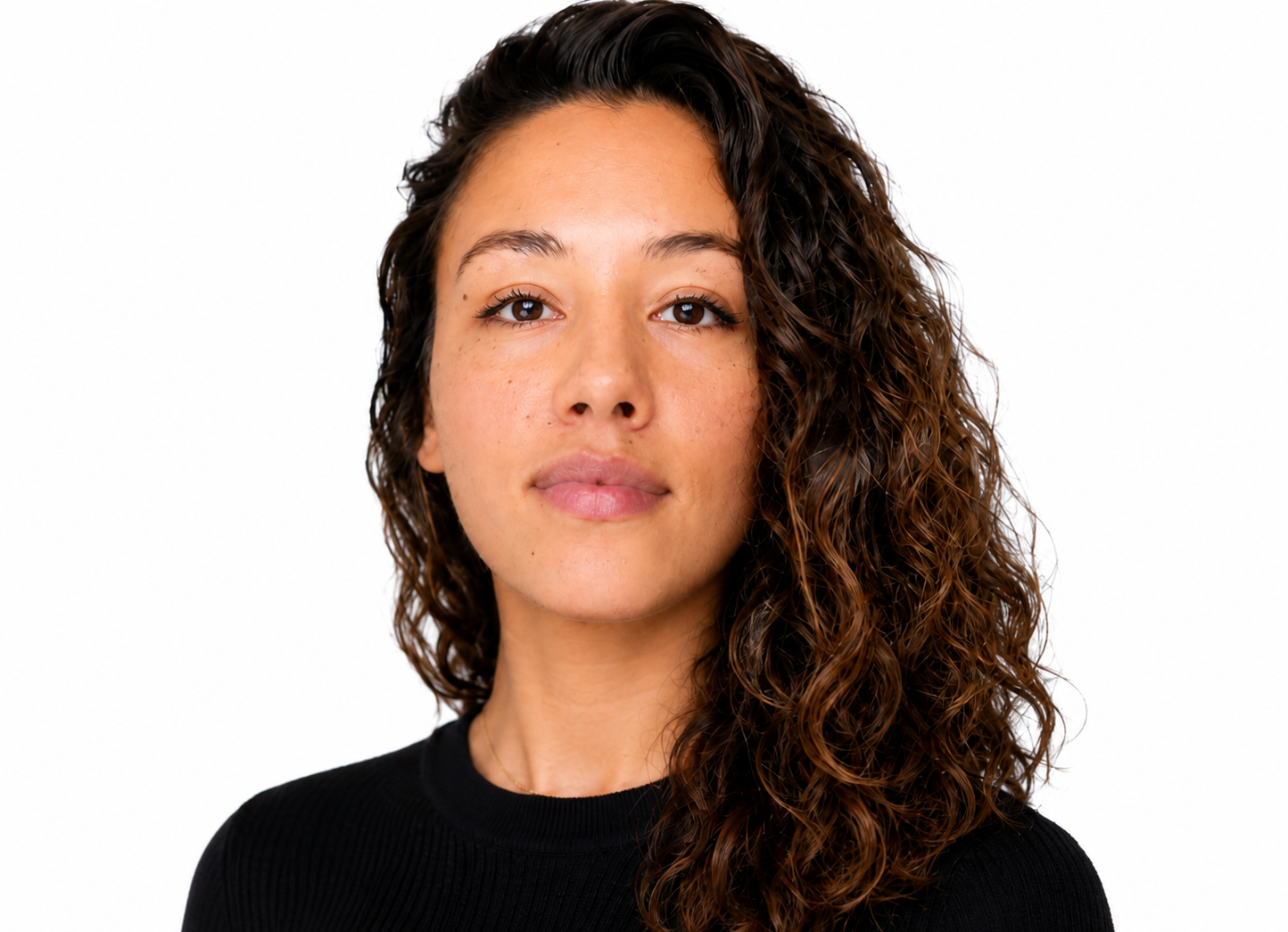 Portret van een persoon met krullend donker haar, gekleed in een zwarte top, tegen een witte achtergrond.