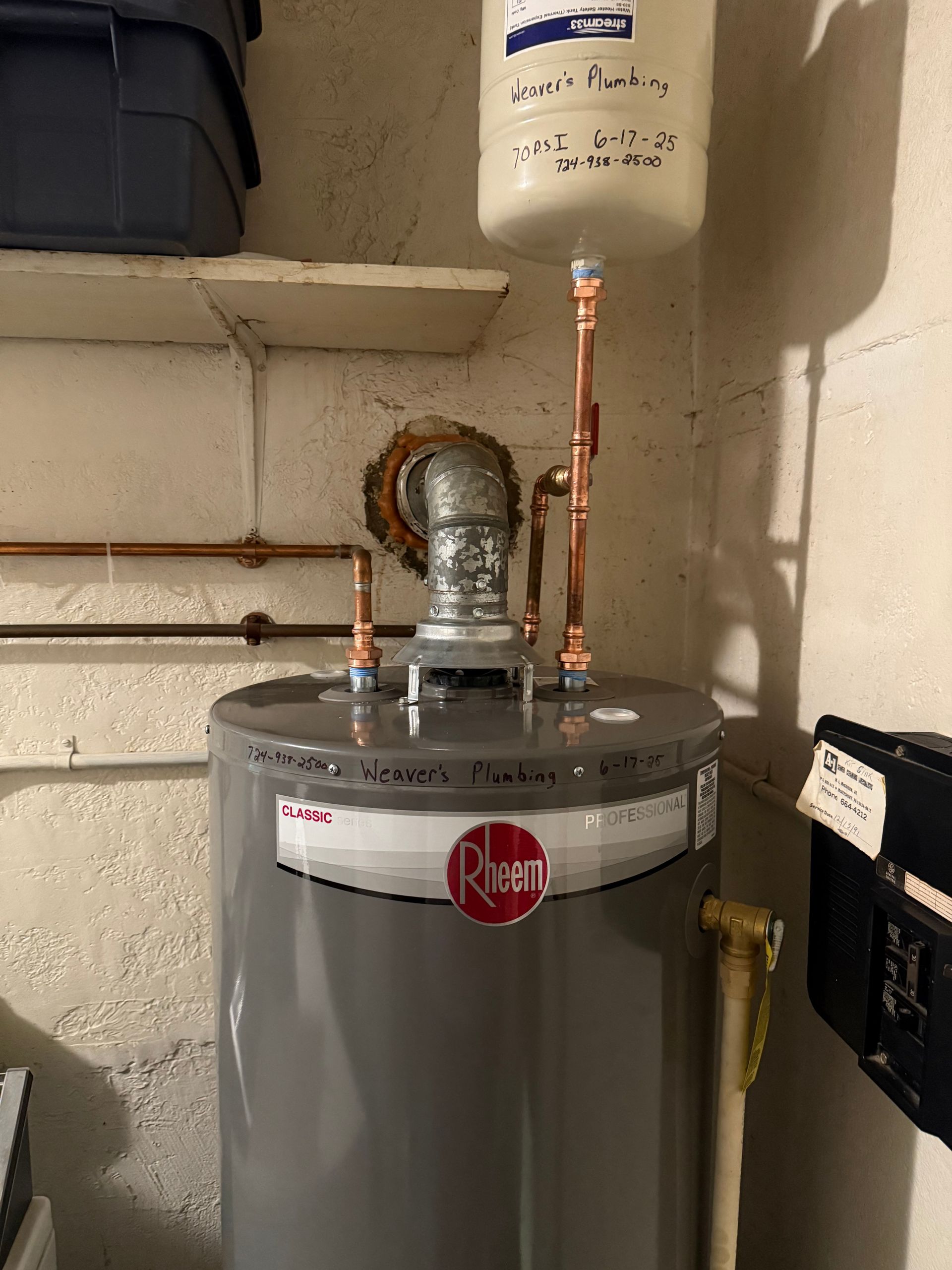 A laundry room with a water heater and a window.