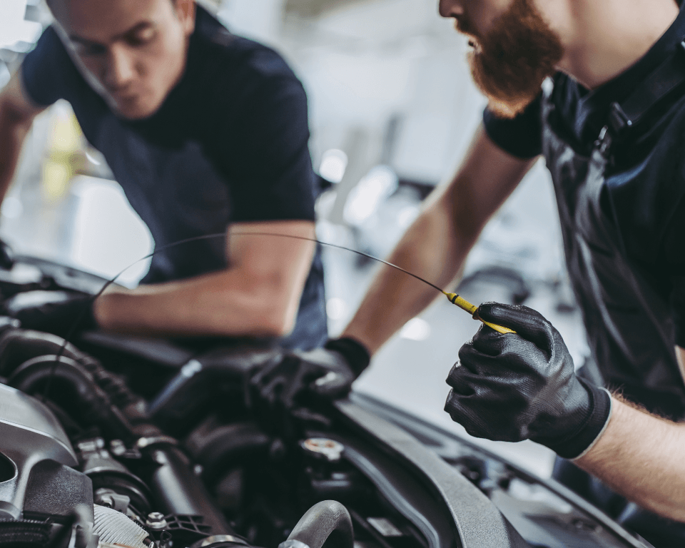 two mechanics doing an oil change